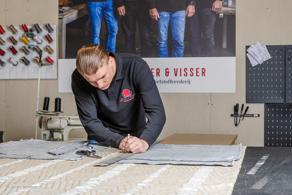 Detailfoto van strak afgewerkte stoffering op moderne fauteuil en designstoel