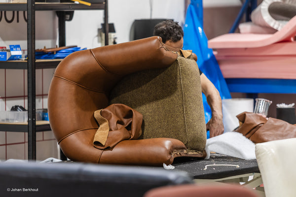 Ambachtelijke meubelstoffeerder aan het werk met het stofferen van een vintage stoel